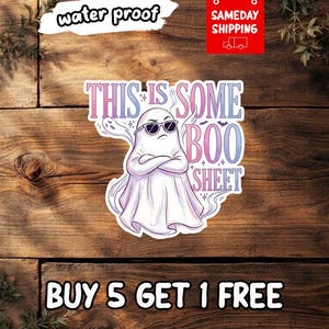 May include: A die-cut sticker featuring a white ghost wearing black sunglasses with arms crossed. The text reads THIS IS SOME BOO SHEET in a gradient of blue and pink. Small ghost and bat illustrations surround the central figure on a white background.