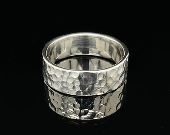 May include: A silver hammered band ring with a textured surface.