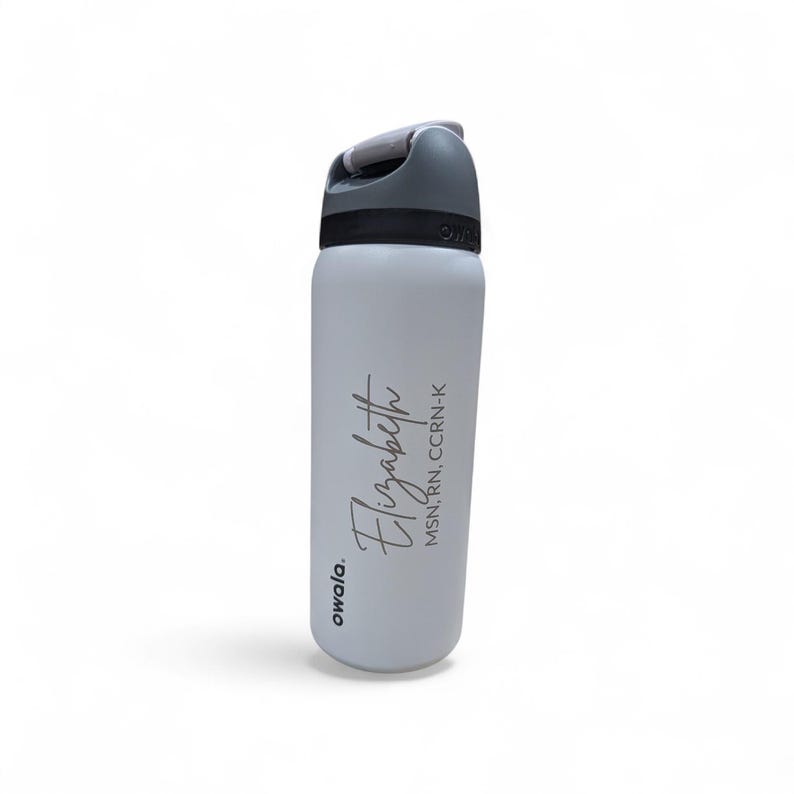 May include: A white Owala water bottle with a gray lid and handle. The bottle features the name Elizabeth printed in a black script font, followed by the credentials MSN, RN, CCRN-K in a smaller, simple black sans-serif font on the side.