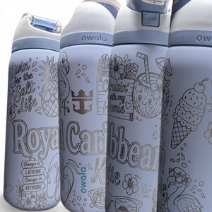 May include: Four light blue Owala water bottles with white lids and blue accents. Each bottle features engraved tropical designs including pineapples, flamingos, ice cream, and text such as Livin' for the Salt Life, Royal Caribbean, and Changes in LATITUDE.