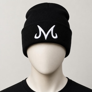 May include: Black knit beanie with a white embroidered "M" logo. The beanie is a classic style, suitable for casual wear. The hat is made of a soft, ribbed knit material.