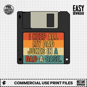May include: A black floppy disk graphic featuring a retro-style label with horizontal stripes in orange, yellow, and light blue. The text reads I KEEP ALL MY DAD JOKES IN A DAD-A-BASE. The design includes a grey sliding metal shutter at the top.