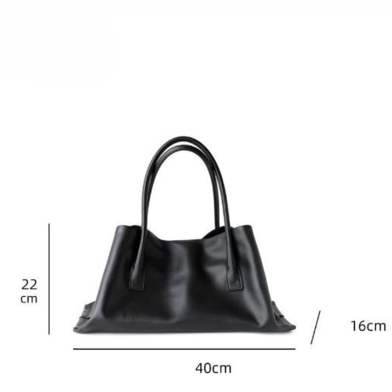 May include: A black tote bag with two handles. The bag is rectangular, with a width of 40 cm, a height of 22 cm, and a depth of 16 cm. The bag is made of a smooth material and has a simple, elegant design.