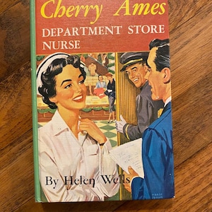 May include: Vintage book cover for "Cherry Ames, Department Store Nurse" by Helen Wells. The cover features a retro illustration of a smiling nurse, a man in uniform, and another man in a blue suit. The title is in yellow letters on a red background.