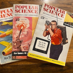 May include: Three vintage Popular Science Monthly magazines from June 1951. The covers feature illustrations of yellow aircraft, a military artillery cannon firing, and a person wearing a portable television camera backpack with the text How TV Will Take You to Conventions.