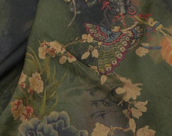 May include: A dark green fabric featuring a printed pattern of a large, colorful butterfly with intricate wing details, surrounded by light-colored cherry blossoms, dark blue peony-like flowers, and thin, winding branches on a textured background.