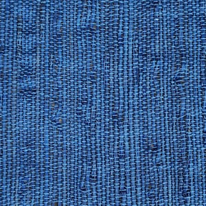 Puede incluir: Una vista de cerca de una tela tejida que presenta una paleta de colores azul profundo. El textil muestra un patrón de cuadrícula distintivo creado por el entrelazado de hilos verticales y horizontales, lo que resulta en una superficie texturizada con huecos.