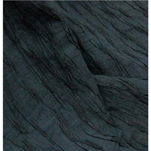 Könnte beinhalten: Ein dunkel anthrazitfarbener Stoff mit einer ausgeprägten, zerknitterten Textur und vertikalen, erhabenen, etwas dunkleren Linienmustern, die sich durch das Material ziehen und eine dimensionale, plissierte Optik erzeugen.