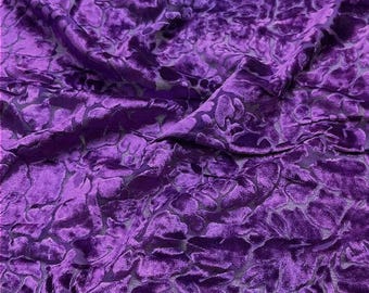 Può includere: Un tessuto in velluto viola intenso caratterizzato da un motivo floreale in rilievo e testurizzato. Il materiale presenta un pelo morbido e felpato con una lucentezza distinta, creando luci e ombre sulle forme organiche del disegno.