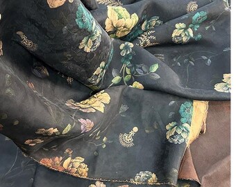May include: A dark charcoal fabric featuring a repeating floral pattern with muted yellow, teal, and purple blossoms. The textile displays intricate botanical illustrations and small decorative motifs scattered across the surface with a soft matte finish.