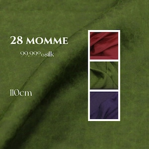 Puede incluir: Una muestra de tela de seda verde oliva con textura mate. El texto en la tela dice 28 MOMME, 99.99% silk y 110cm. Una columna vertical a la derecha muestra tres muestras de tela más pequeñas en colores rojo oscuro, verde oliva y morado.