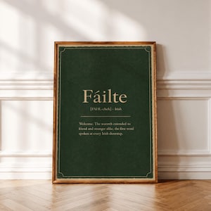 May include: A rectangular framed wall art print featuring a dark forest green background with a textured appearance. The text Fáilte is printed in a light cream colour, followed by the phonetic pronunciation and the definition of the word.