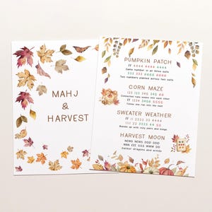 May include: Two white cards featuring watercolor autumn leaves in shades of red, orange, and yellow. The left card reads MAHJ & HARVEST. The right card lists PUMPKIN PATCH, CORN MAZE, SWEATER WEATHER, and HARVEST MOON with game instructions and text.