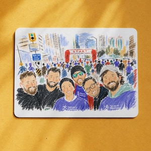 Puede incluir: Una impresión rectangular con una colorida ilustración al estilo de crayón de un grupo de seis personas posando frente a la línea de salida del Maratón de Toronto. La escena incluye edificios, una multitud de corredores y un arco rojo START.