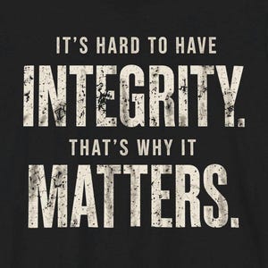 May include: Black t-shirt with white text that reads "IT'S HARD TO HAVE INTEGRITY. THAT'S WHY IT MATTERS." The text has a distressed, vintage look.