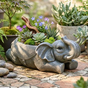 May include: A gray elephant-shaped planter filled with succulents, moss, and small purple and blue flowers. The elephant is lying down with its trunk raised. The planter is made of a stone-like material and sits on a brick patio.