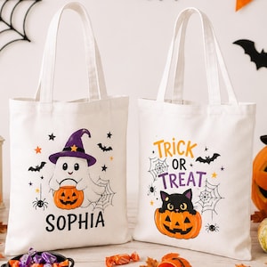 Peut inclure: Deux sacs fourre-tout en toile blanche avec des motifs d'Halloween. Le sac de gauche montre un fantôme portant un chapeau violet tenant une citrouille avec le nom SOPHIA imprimé en dessous. Le sac de droite affiche un chat noir dans une citrouille.