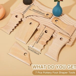 May include: A set of seven light-coloured wooden pottery foot shaper tools with various edge profiles, each featuring a circular hole. The tools include printed dimensions such as 11.5 cm, 14 cm, and 8 cm. Text reads: WHAT DO YOU GET: 7 Pcs Pottery Foot Shaper Tools.