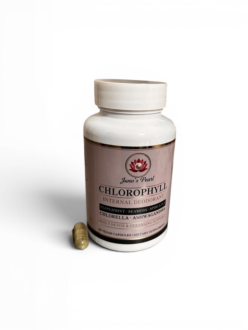 Puede incluir: Una botella blanca de Juno's Pearl Chlorophyll Internal Deodorant con una etiqueta rosa y una c&aacute;psula al lado. La etiqueta enumera ingredientes como menta, musgo marino y chlorella. La botella contiene 60 c&aacute;psulas veganas.