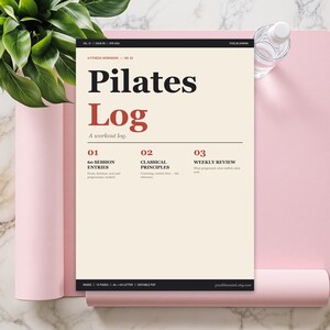 Peut inclure: Un cahier de Pilates Log avec le titre en grandes lettres noires et le mot « Log » en rouge. Le cahier est posé sur un tapis de yoga rose, avec une bouteille d'eau et une plante en arrière-plan.