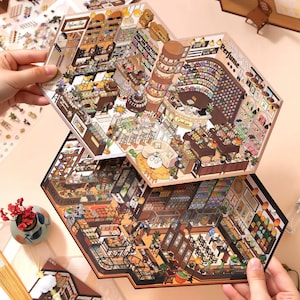 May include: Two hexagonal paper sheets featuring detailed isometric illustrations of shop interiors. The top sheet depicts a perfume shop with shelves of bottles and a cashier counter. The bottom sheet shows a store with various goods and furniture.