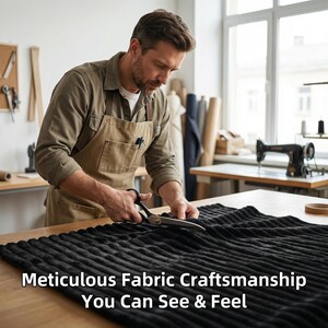 Op de afbeelding: Een persoon met een schort knipt met een schaar een stuk zwarte stof met een geribbelde textuur. De tekst "Meticulous Fabric Craftsmanship You Can See & Feel" wordt onderaan de afbeelding weergegeven.