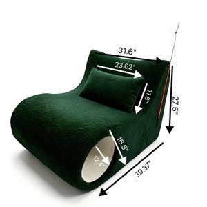 May include: A dark green, plush pet bed with a curved design. The bed includes a rectangular pillow and a tunnel-like opening. Dimensions are 39.37" long, 31.6" wide, and 27.5" high. The pillow is 23.62" x 11.8".