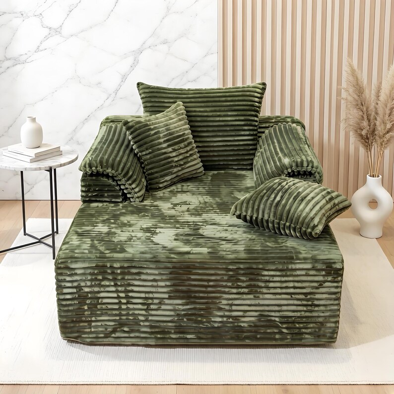 May include: A green corduroy sofa with matching cushions. The sofa has a low profile and a textured, ribbed design. The cushions are in various sizes and shapes, adding to the cosy aesthetic. The colour is a muted, earthy green.