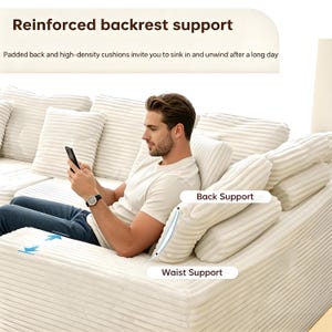 May include: A white corduroy sofa with multiple cushions, featuring "Reinforced backrest support" text. The sofa has back and waist support cushions. A person is sitting on the sofa, holding a phone.