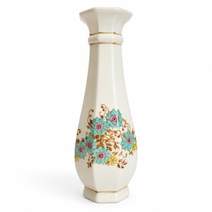 May include: A tall, off-white hexagonal vase featuring a flared rim and a tapered neck. The body is decorated with a floral pattern of turquoise and pink blossoms with yellow accents and brown stems. Thin gold lines accent the rim and base.