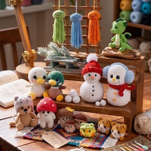 Puede incluir: Una colección de artículos de ganchillo hechos a mano, que incluyen medusas, un dragón, muñecos de nieve, patos, un oso, setas y gatos. Los artículos se exhiben en una estantería y una mesa de madera, con una lámpara y materiales de manualidades en el fondo. La etiqueta dice "Etsy Handmade".