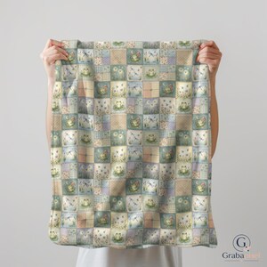 K&ouml;nnte beinhalten: Eine Patchwork-Decke mit einem sich wiederholenden Muster aus Quadraten. Jedes Quadrat zeigt Illustrationen von Fr&ouml;schen, Libellen, Blumen und Monden in Pastellt&ouml;nen. Das Design schafft eine gem&uuml;tliche, von der Natur inspirierte &Auml;sthetik.