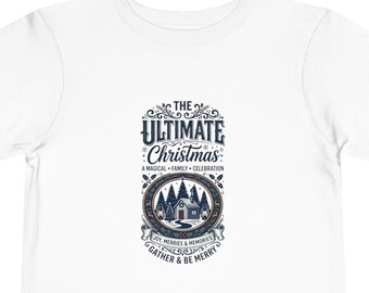 May include: A white short-sleeve t-shirt featuring a central graphic with the text THE ULTIMATE Christmas A MAGICAL FAMILY CELEBRATION JOY, MERRIES & MEMORIES GATHER & BE MERRY surrounding an illustration of a cabin in a snowy forest.