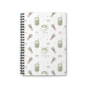 May include: A spiral-bound notebook with a white cover. The cover design features a repeating pattern of matcha drinks, whisks, bows, and text. The text includes "stay soft" and "mine's a matcha, slow mornings only". The design is in green, beige, and brown.