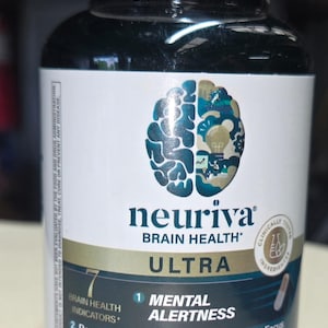 May include: A dark green Neuriva Ultra dietary supplement bottle with a white cap. The label features the Neuriva logo, a brain graphic, and text highlighting mental alertness, memory, and focus. Contains 60 capsules.