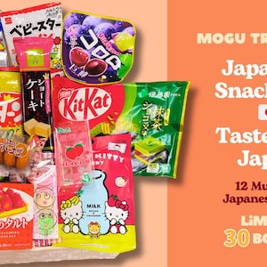 Puede incluir: Una caja de snacks japoneses, que incluye patatas fritas, barritas Kit Kat y varios caramelos. La caja está etiquetada como "Japanese Snack Box" y "Taste Real Japan". También aparece el texto "12 Must-Try Japanese Treats".