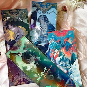 May include: Four rectangular bookmarks featuring anime-style character illustrations with ornate gold filigree borders. The designs include deep blue, green, and vibrant multi-colored abstract backgrounds with text overlays including Bethel Ab and Kevin Quett.