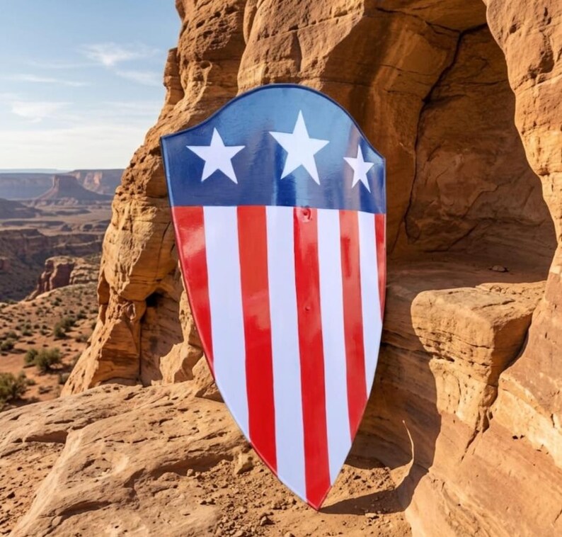 May include: A pointed shield featuring a glossy finish with a dark blue upper section containing three white five-pointed stars, and a lower section with alternating vertical red and white stripes. The shield has a smooth, curved surface.