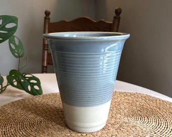 Jarrón o maceta de cerámica azul y arena, hecho a mano en estudio, con forma de trompeta.