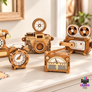 May include: Five laser-cut wooden models including a rotary telephone, an alarm clock, a camera, a film projector, and a radio. The text on the right side reads 5 DESIGN LASER CUT READY FILES, CDR, PNG, SVG, PDF, EPS, DFX, MATERIA WIDTH 3MM.