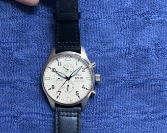 Orologio cronografo IWC Pilot vintage: quadrante bianco, cinturino in pelle nera, stile aviatore.