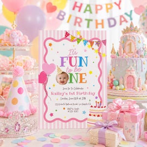 May include: A birthday celebration scene featuring a pink invitation card with the text "It's FUN to be ONE" and a baby's photo. A multi-tiered cake, party hats, balloons, and gifts create a joyful atmosphere.