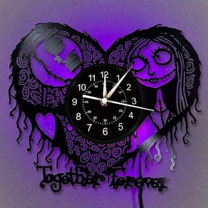 May include: A black heart-shaped wall clock with a purple backlight. The clock features a silhouette of a couple and the words "Together Forever". The clock face is black with white numbers and hands.