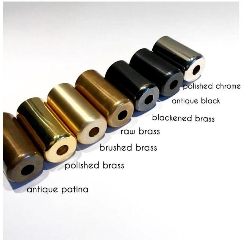 May include: An array of cylindrical metal objects in various finishes, including polished chrome, antique black, and antique patina. The image displays the different colors and textures of the metal, with labels identifying each finish.
