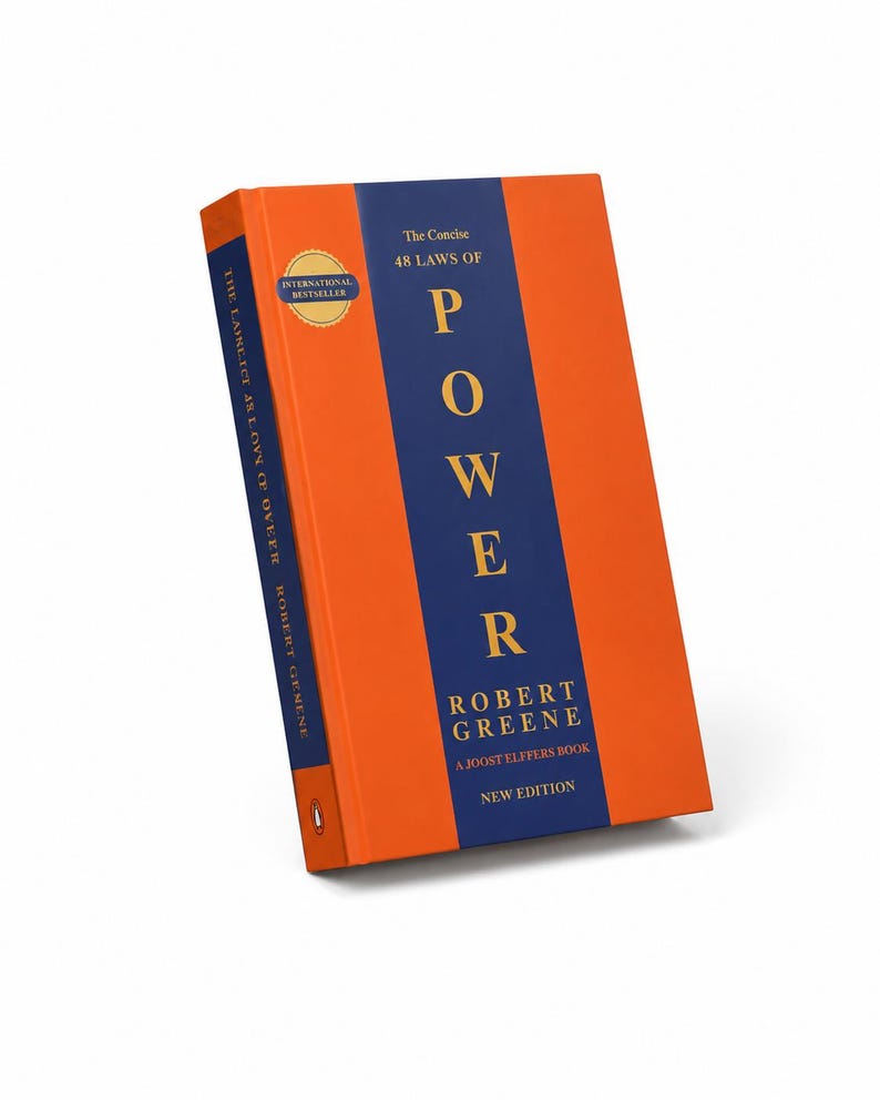 Pu&ograve; includere: Il libro The Concise 48 Laws of Power di Robert Greene presenta una copertina arancione brillante con una striscia verticale blu scuro al centro. Il titolo &egrave; stampato in lettere dorate e sulla copertina &egrave; visibile un sigillo dorato International Bestseller.