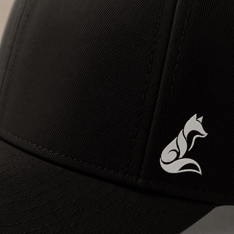 Pode incluir: Bon&eacute; de beisebol preto com um logotipo de raposa branco na lateral. O bon&eacute; &eacute; feito de um tecido dur&aacute;vel e apresenta uma aba curva. O logotipo da raposa &eacute; um design estilizado.