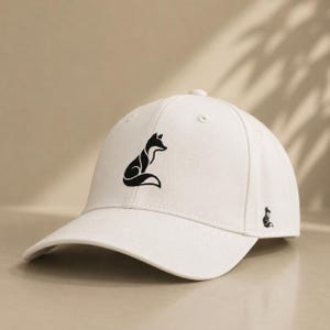 Pode incluir: Bon&eacute; de beisebol branco com uma silhueta de raposa preta na frente e um logotipo de raposa menor na lateral. O bon&eacute; tem uma aba curva e um design cl&aacute;ssico de seis pain&eacute;is.