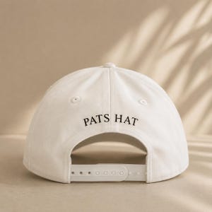 Pode incluir: Bon&eacute; de beisebol branco com o texto "PATS HAT" em preto. O bon&eacute; tem uma aba curva e uma al&ccedil;a ajust&aacute;vel na parte de tr&aacute;s. Feito de um material macio e dur&aacute;vel.