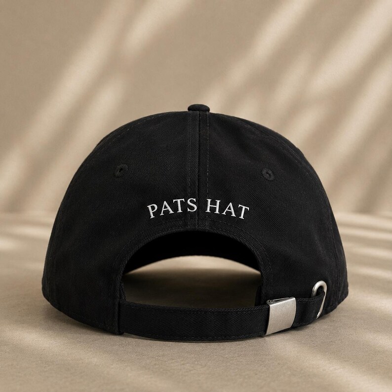 Pode incluir: Bon&eacute; de beisebol preto com o texto "PATS HAT" em branco. O bon&eacute; tem uma aba curva, um fecho de metal e uma al&ccedil;a de tecido para ajuste. O chap&eacute;u &eacute; feito de um material dur&aacute;vel.