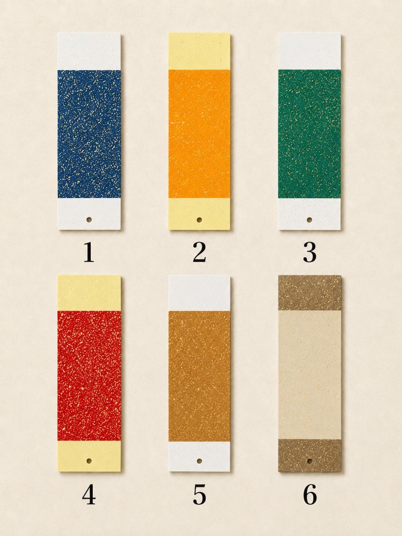May include: Six rectangular paper swatches arranged in two rows, numbered one through six. Each swatch features a central coloured section with a speckled texture, flanked by solid-coloured top and bottom borders, and a small hole at the bottom.